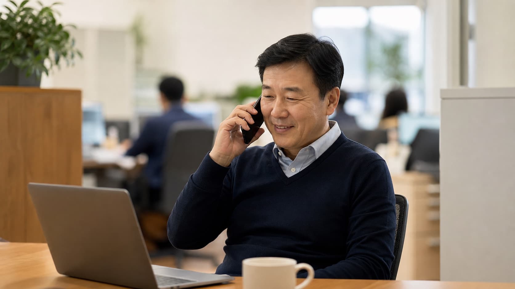 사무실에서 부모 돌봄 상담 전화를 받는 50대 직장인